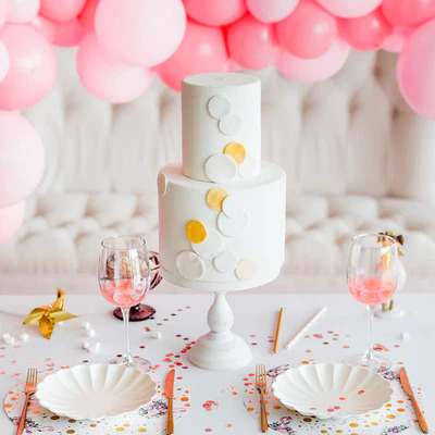 Table Decorated For Cake in Middle And Balloons in Ceiling